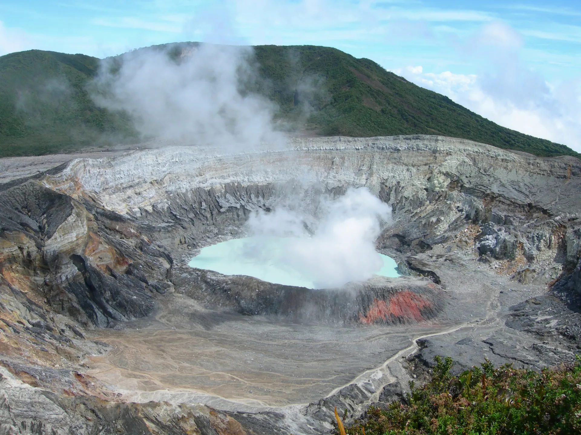 噴気が立ち上るポアス火山の火口と火口湖